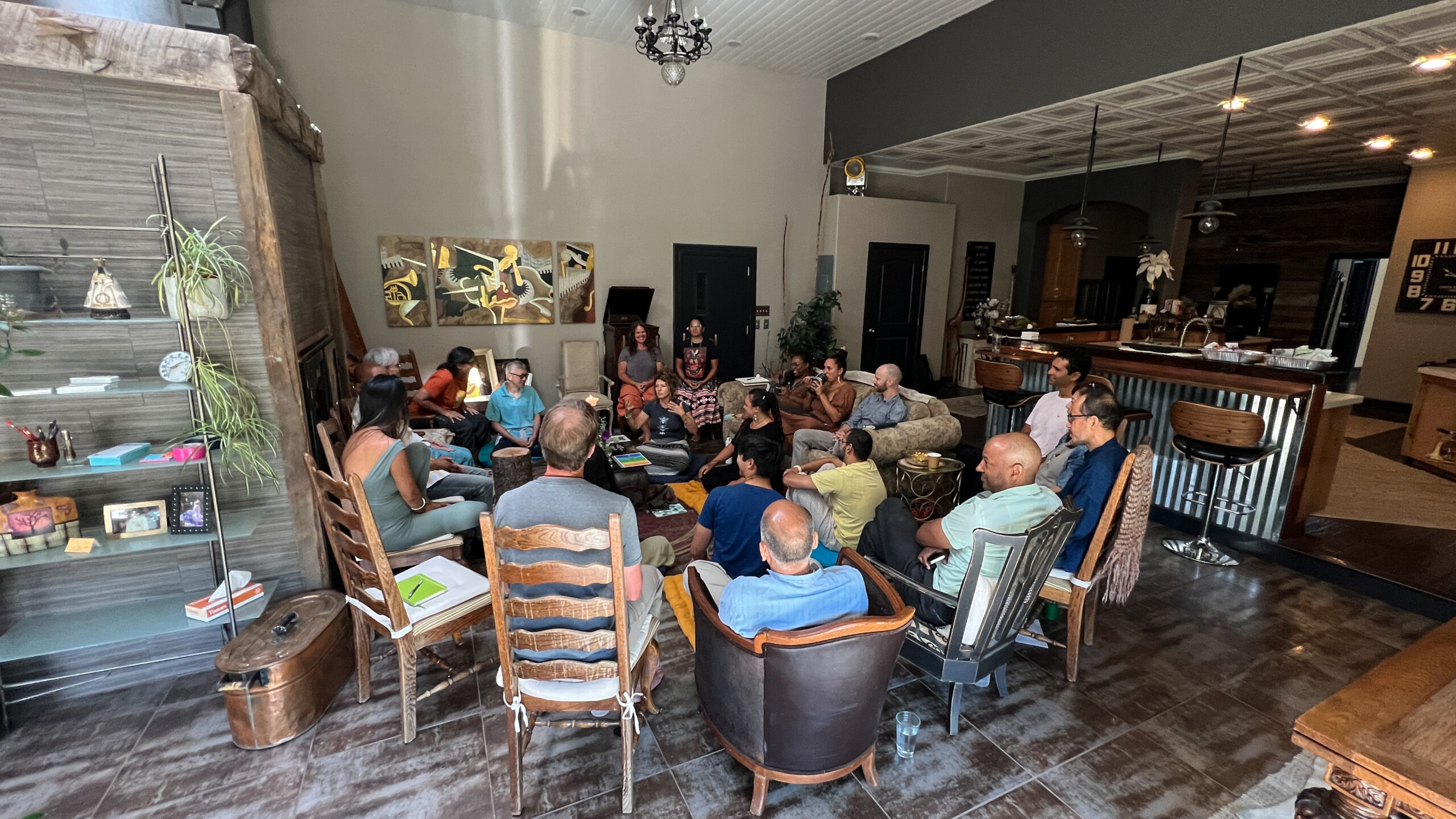 A gathering seated in a circle in the main room