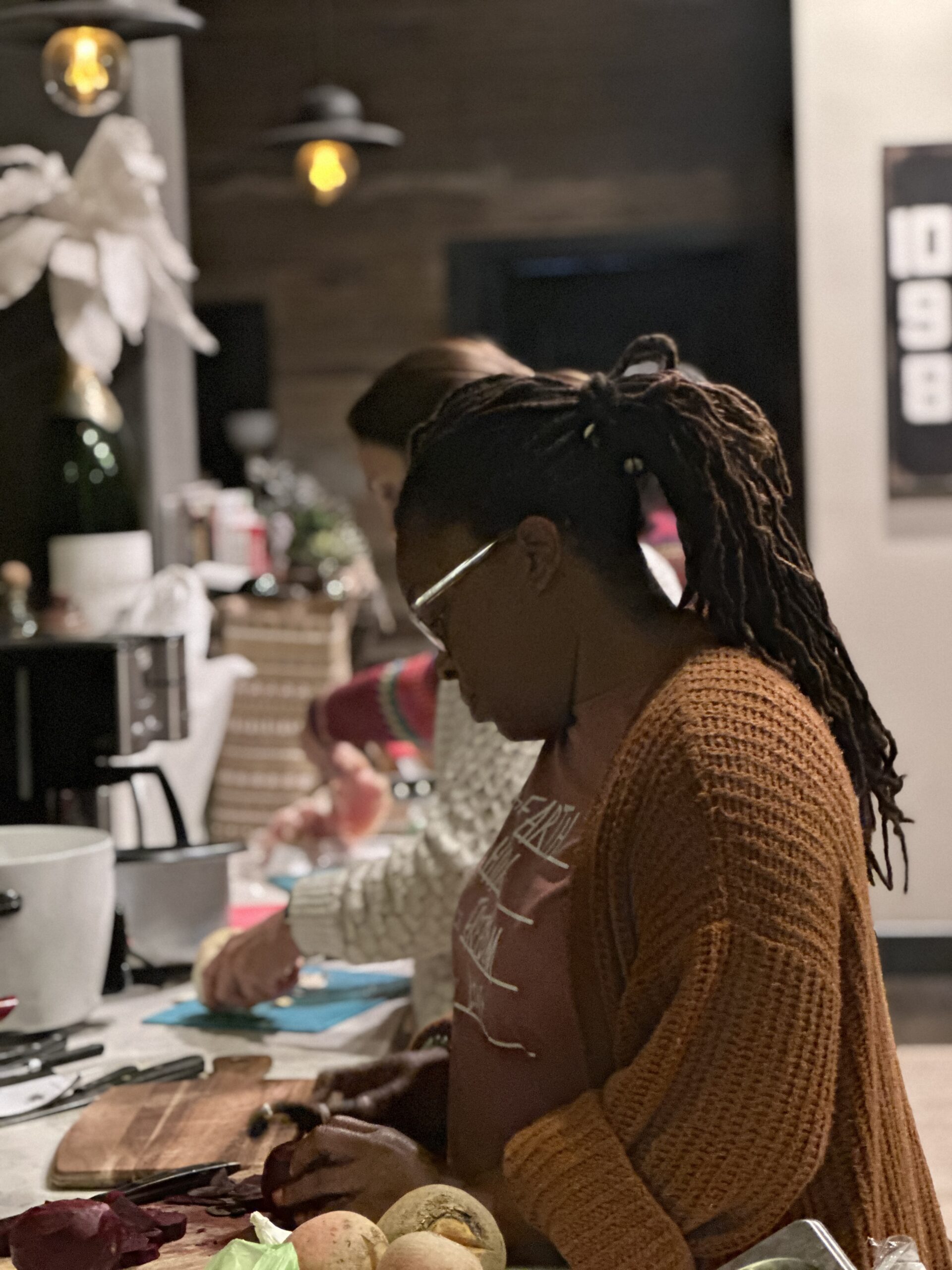 A student preparing food alongside others in the community kitchen