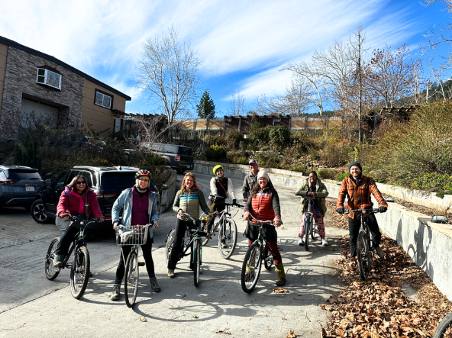 Riders with their bicycles in the driveway on a bright winter day